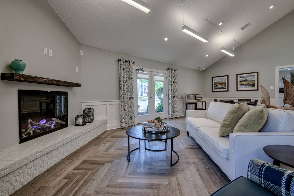 a living room with a couch and a table in front of a fireplace