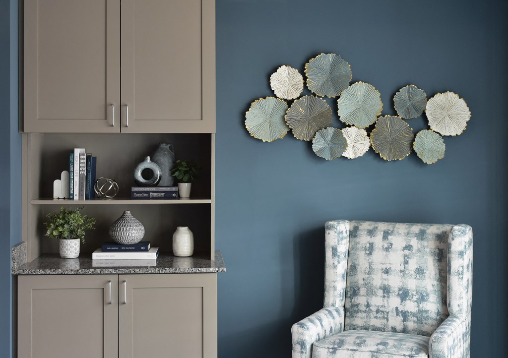 a corner of a living room with a chair and a wall with plates on it