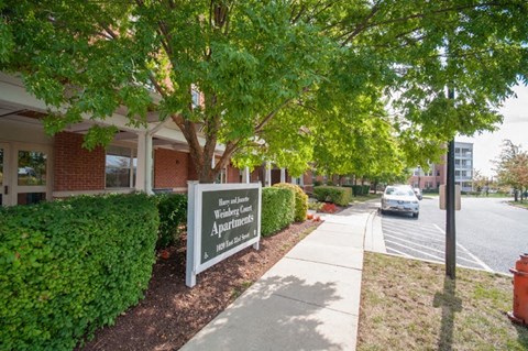 a sign in front of a building with a car on the street