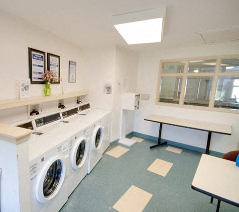 a laundry room with washing machines and a table
