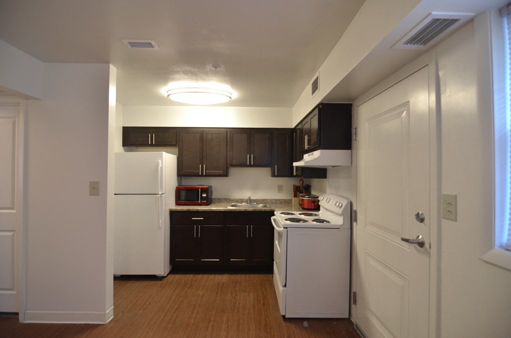 a kitchen with white appliances and black cabinets