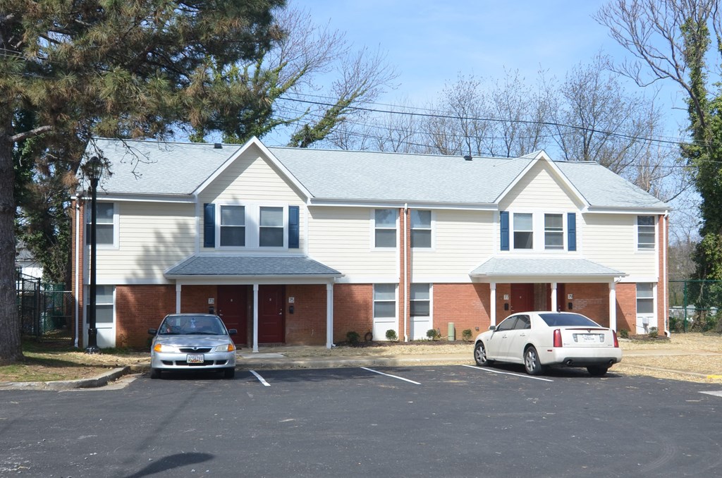 a house with a parking lot and two cars in front of it