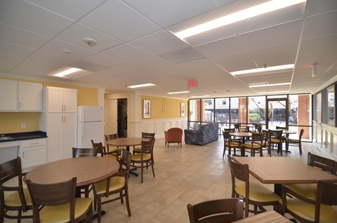 a dining room with tables and chairs and a kitchen