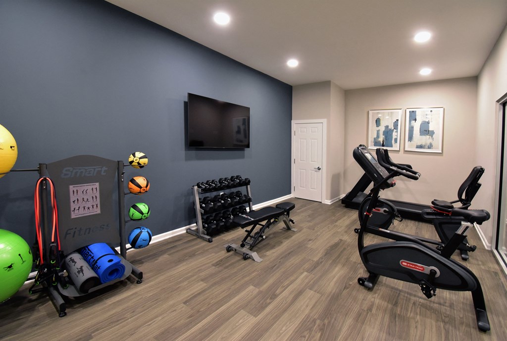 a home gym with exercise equipment and a tv