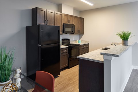 a kitchen with black appliances and a granite counter top