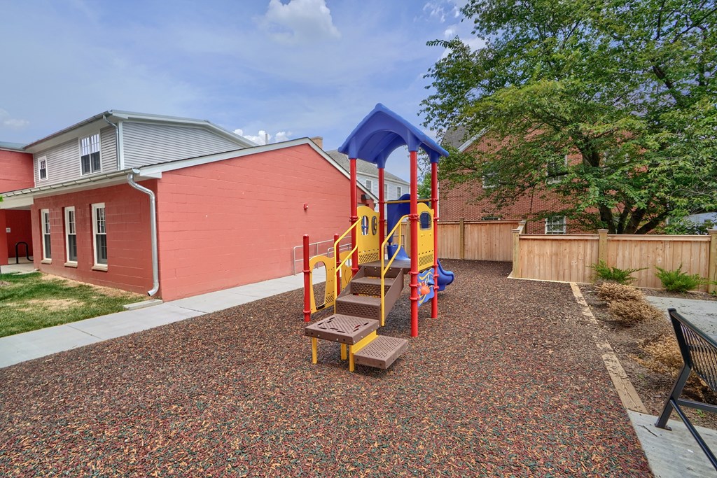 A playground with a slide and a wooden platform.