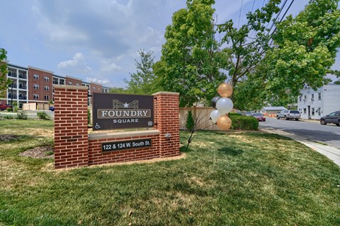 A sign for Foundry Square is in front of a grassy area.