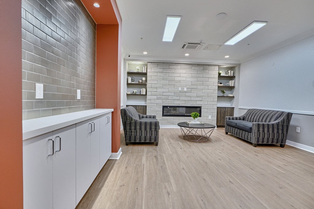 A living room with a fireplace and two chairs.