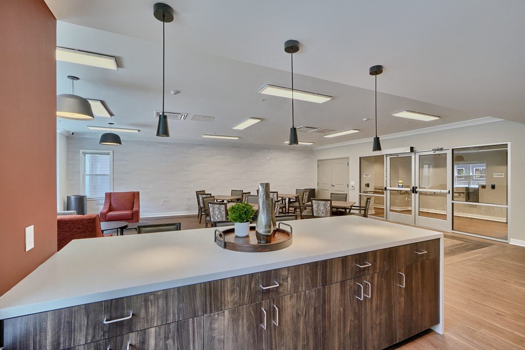 A modern kitchen with a large island and pendant lights.