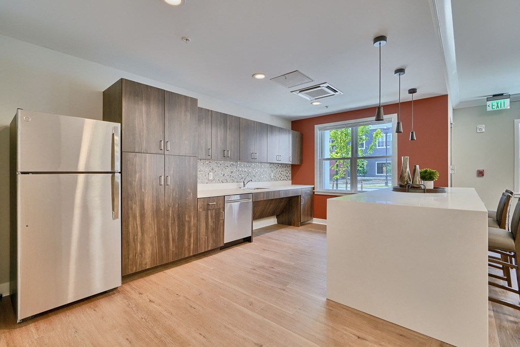A modern kitchen with wooden cabinets and a stainless steel refrigerator.