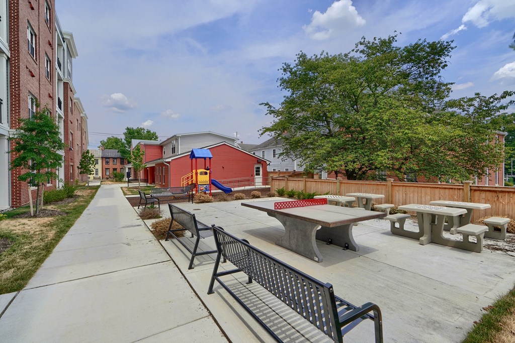 A playground with a slide and picnic tables.