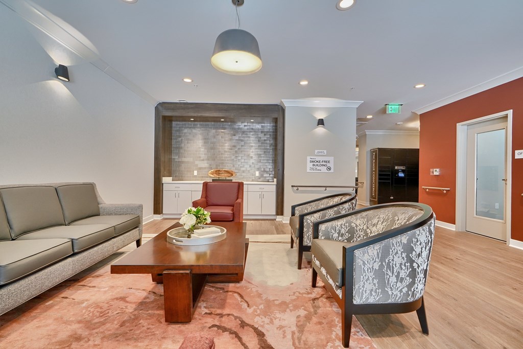 A living room with a grey sofa, a wooden coffee table, and a patterned armchair.