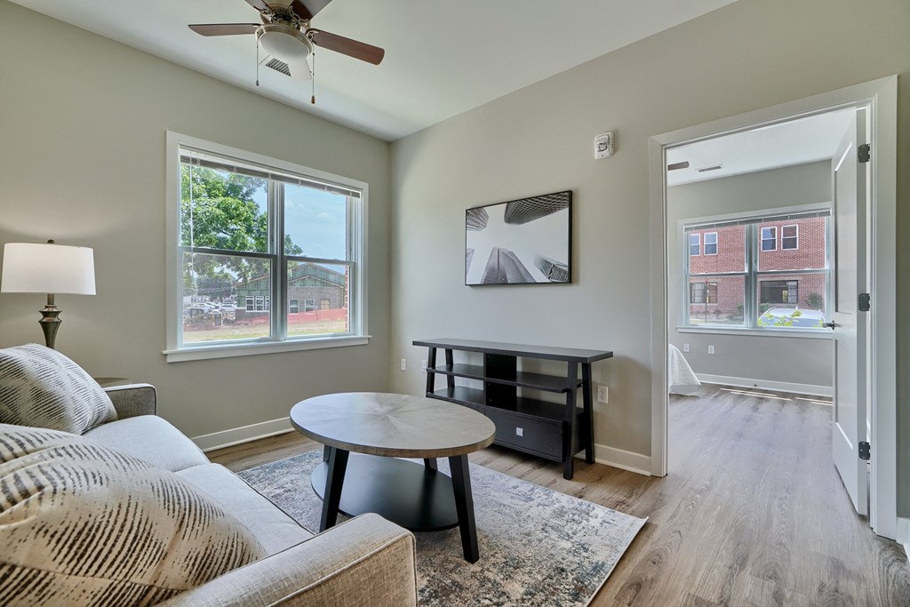 A living room with a couch, a coffee table, and a ceiling fan.