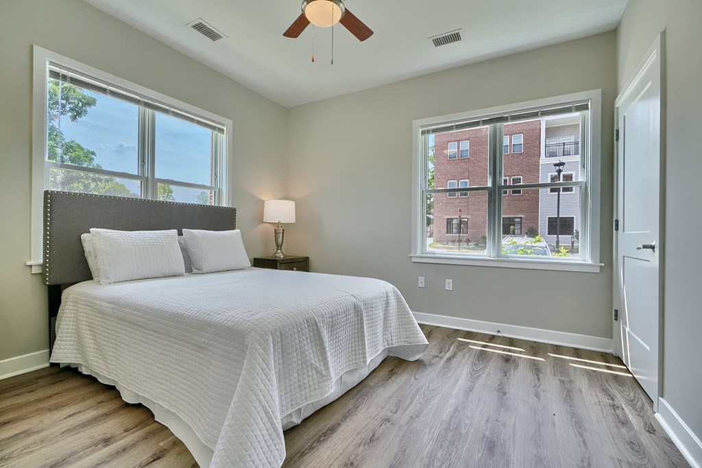 A bedroom with a large bed and a window overlooking a building.