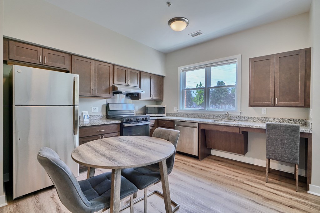 A kitchen with a table and chairs.