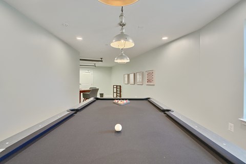 a billiards room with a pool table and two ceiling lights