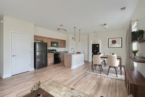 A kitchen with a refrigerator, microwave, oven, and sink.