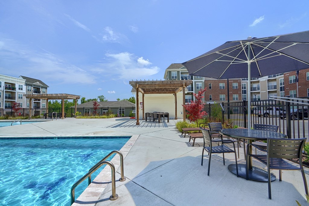 our apartments have a swimming pool with tables and umbrellas