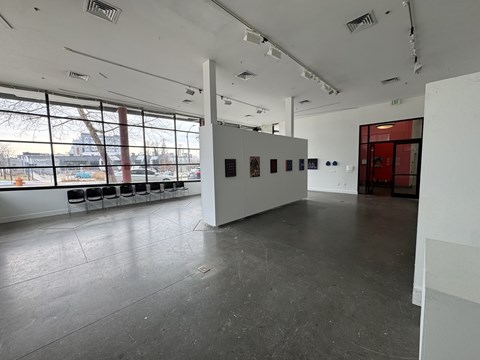 A large, empty room with white walls and a grey floor.