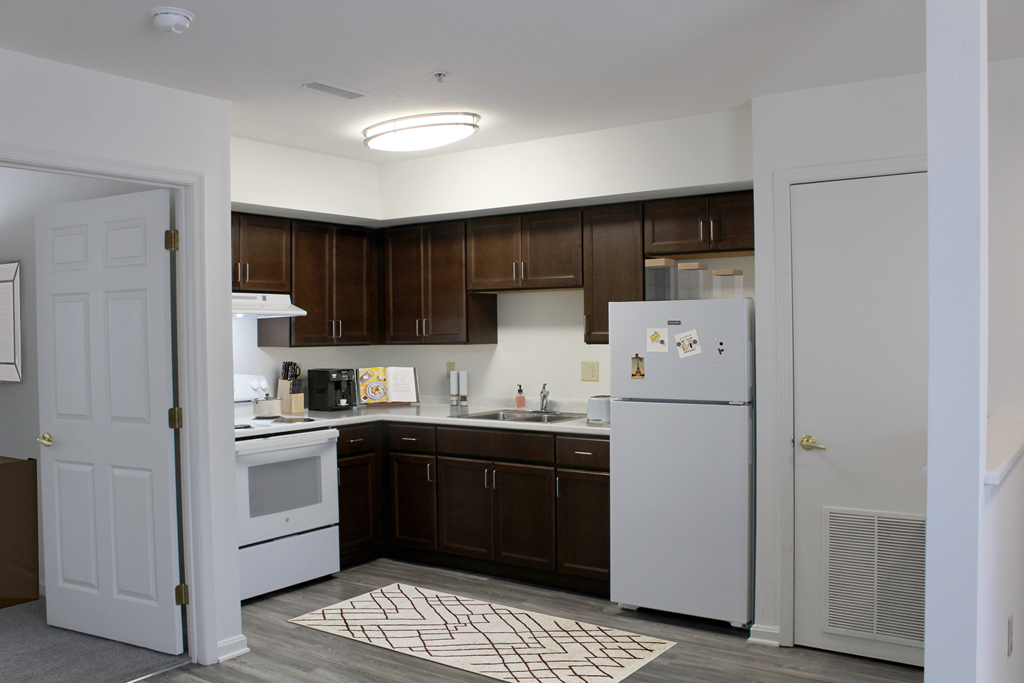 a kitchen with white appliances and dark wood cabinets