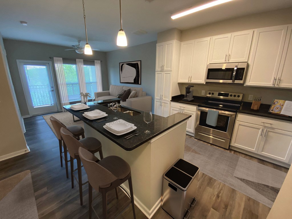 an open kitchen and living room with an island and a table with chairs