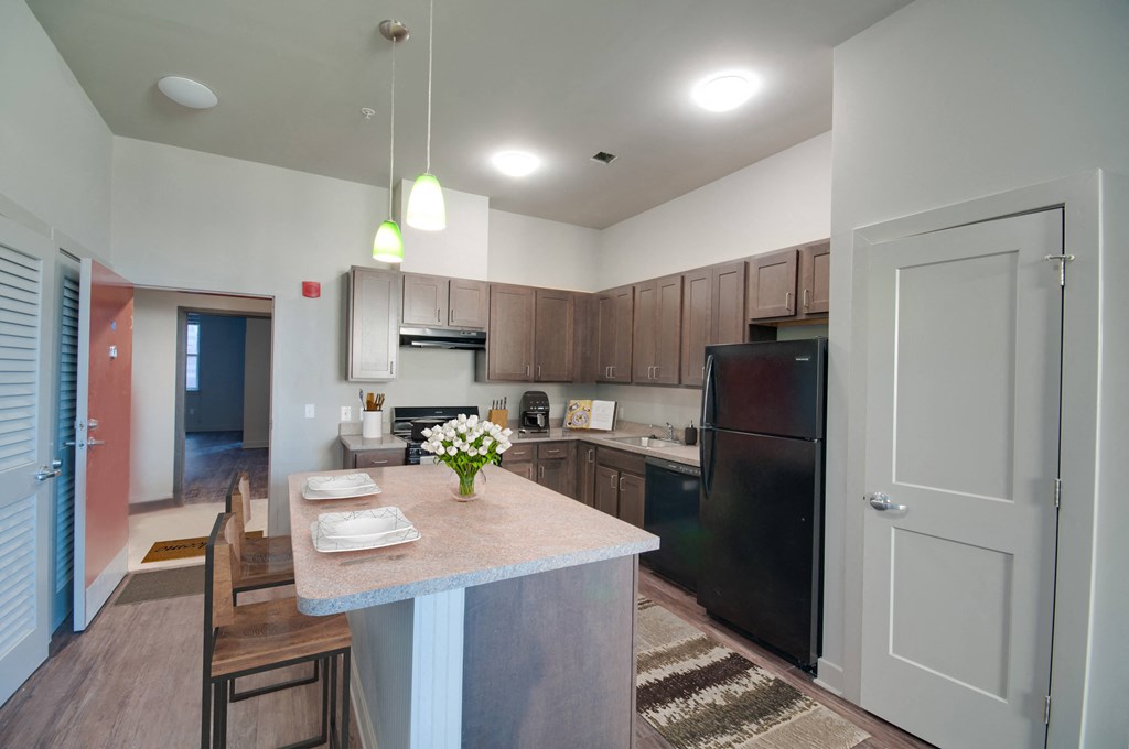 a kitchen with a large island and a black refrigerator