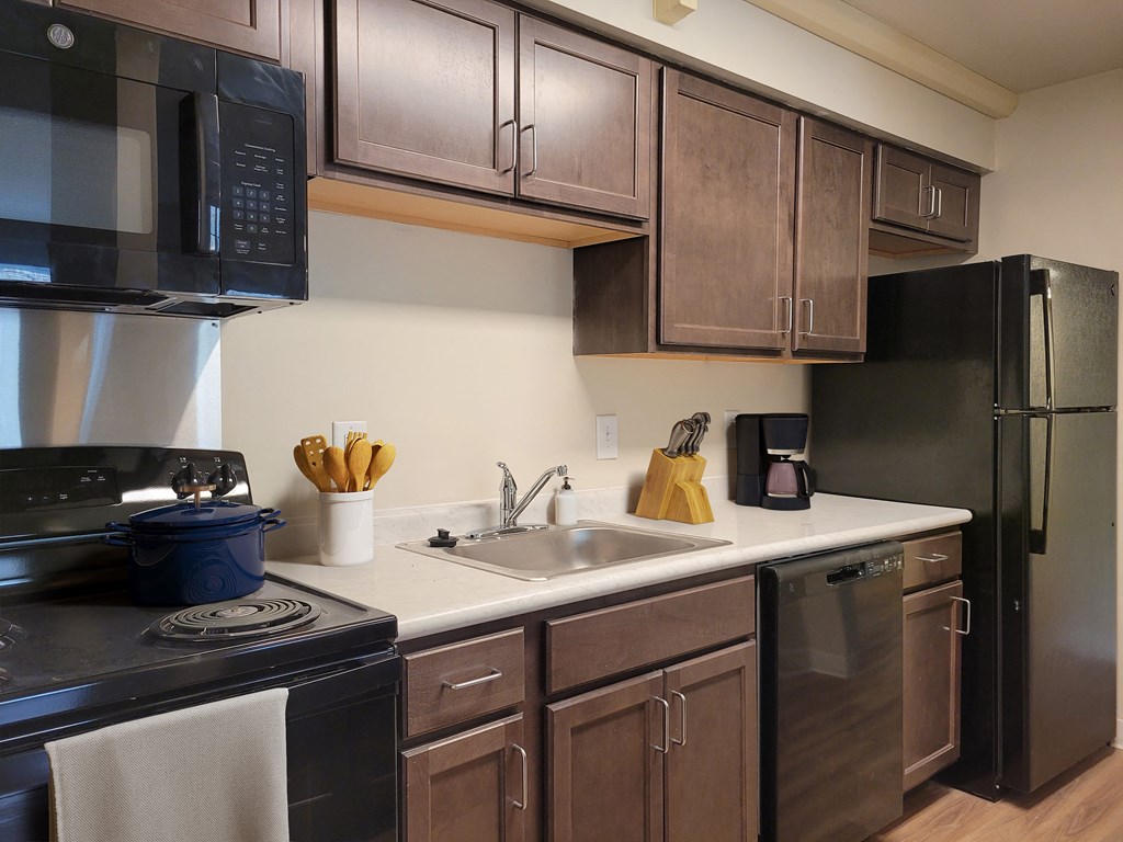 a kitchen with stainless steel appliances and dark wood cabinets