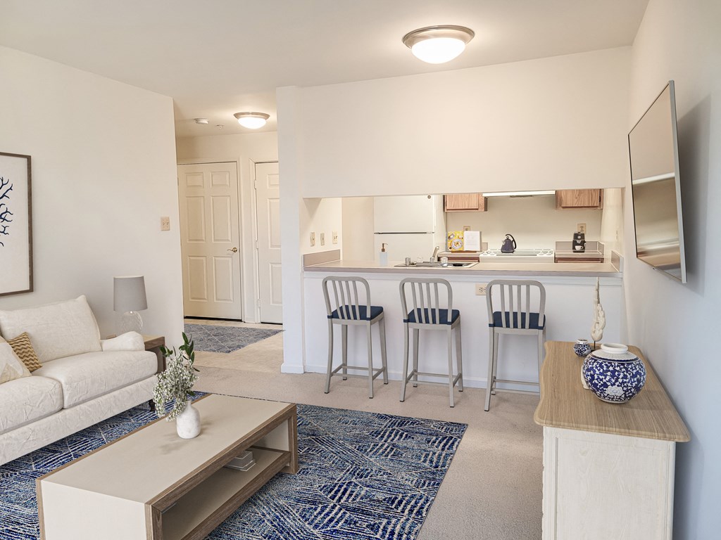 a living room with a couch and a kitchen with a bar
