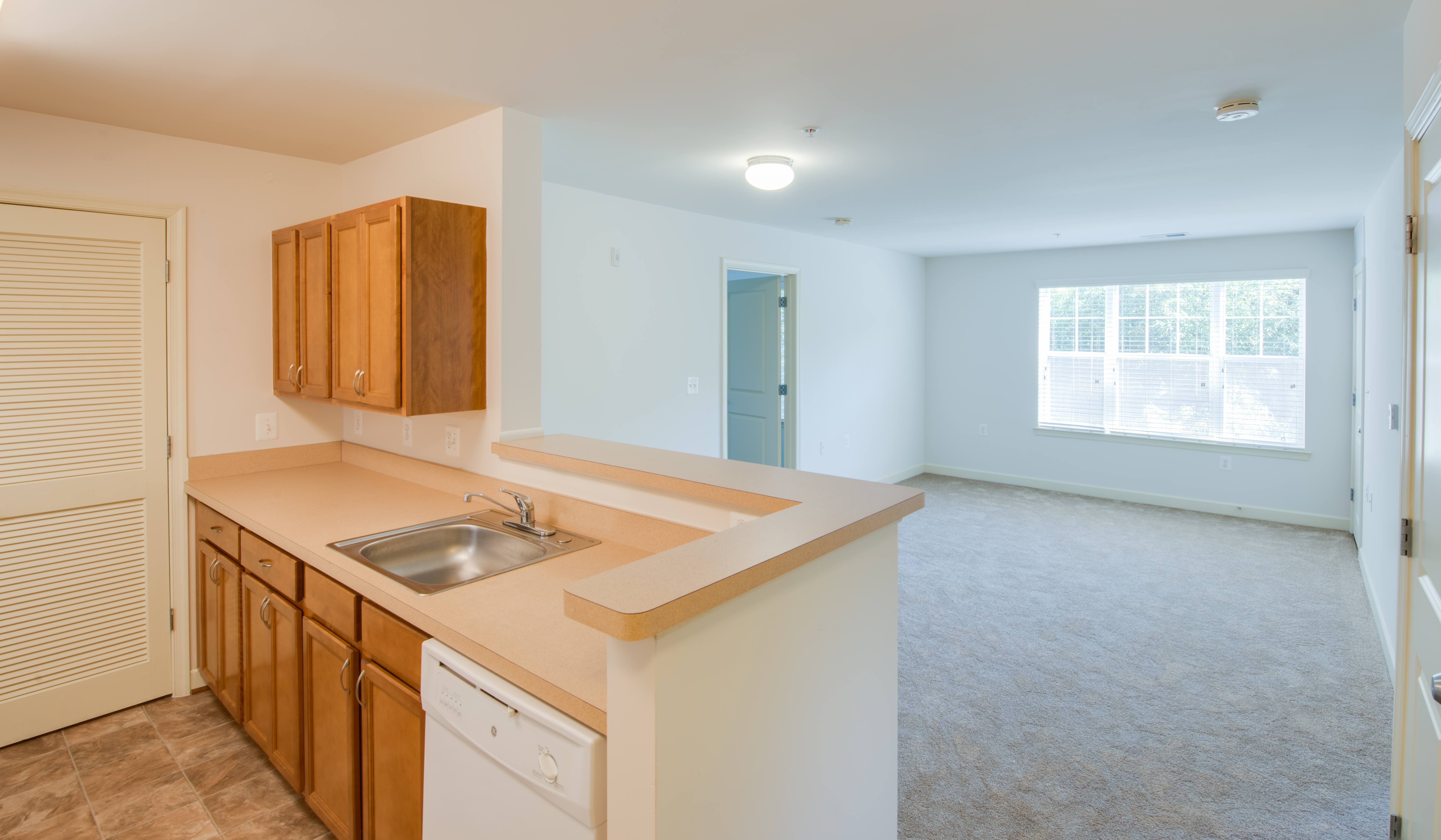 A kitchen with wooden cabinets and a white dishwasher.