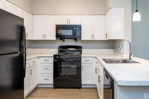 a kitchen with white cabinets and black appliances