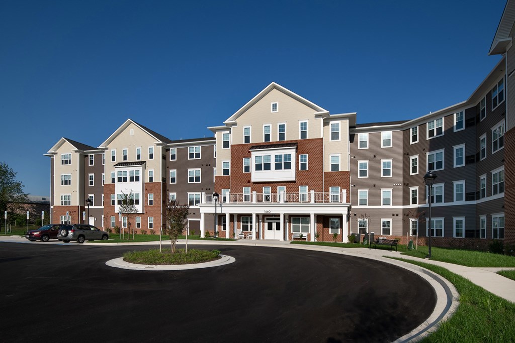 a roundabout in front of an apartment building with a blue sky background