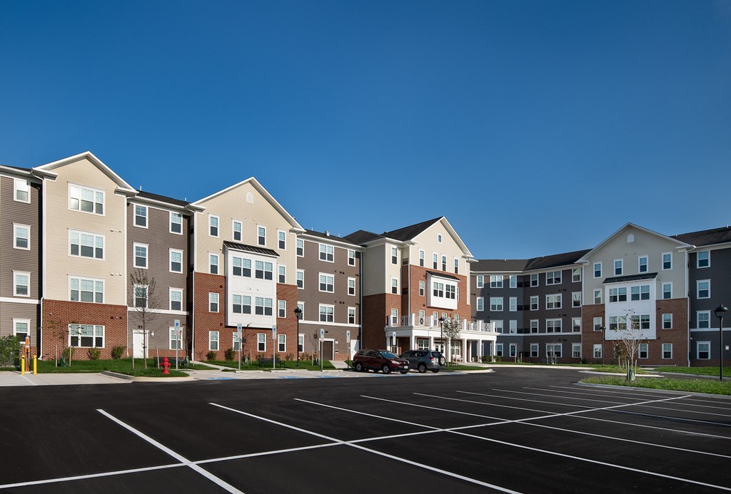 an empty parking lot in front of an apartment building