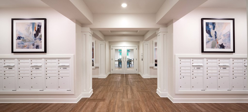 a long hallway with white cabinets and white walls and wood floors