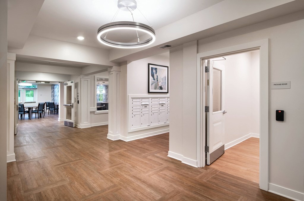 a renovated living room and dining room with wood flooring and white walls