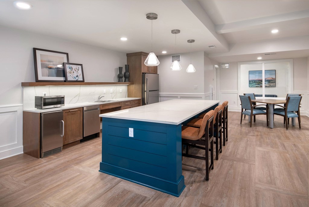 a kitchen with a blue island and a dining room with chairs