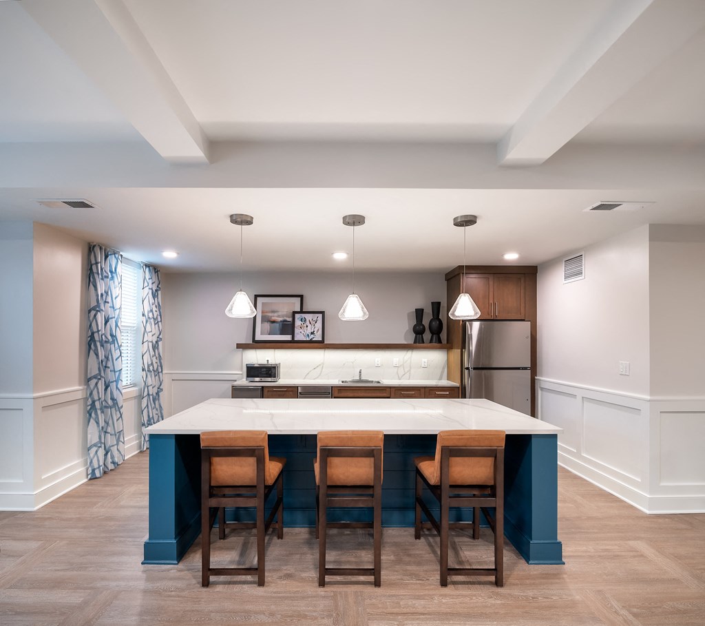 a kitchen with a blue island and wooden chairs