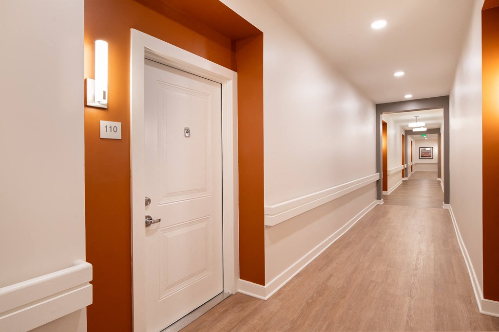 a corridor with a white door and a hallway with orange walls