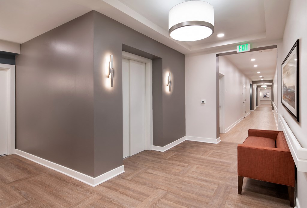 a hallway with a couch and a chair and a corridor with doors