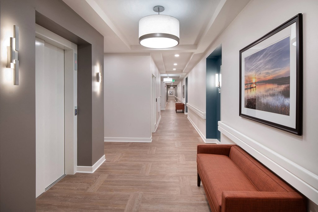 a long hallway with a bench and a painting on the wall