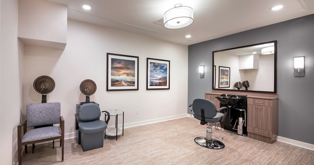 a salon room with two chairs and a mirror
