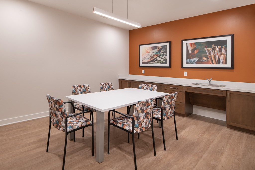 a dining area with a table and chairs and a sink