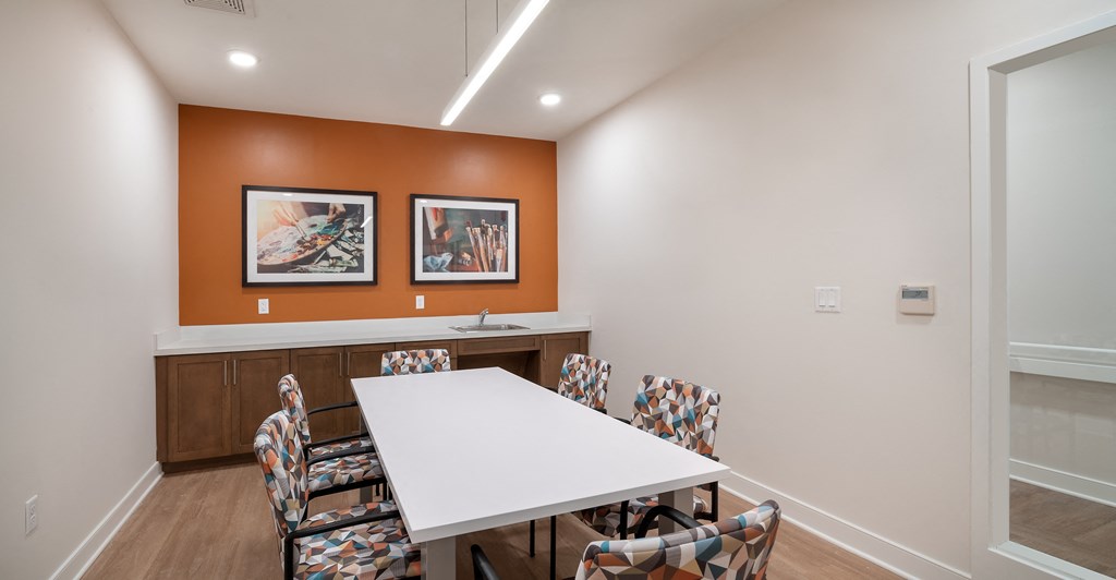 a meeting room with a white table and chairs
