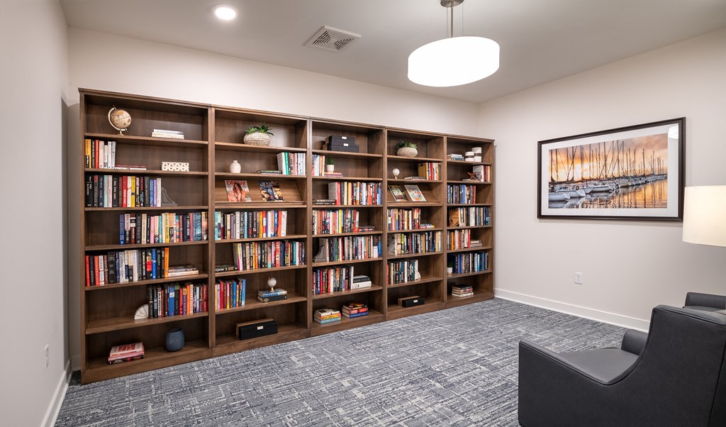 room with bookshelves and a couch in front of a window