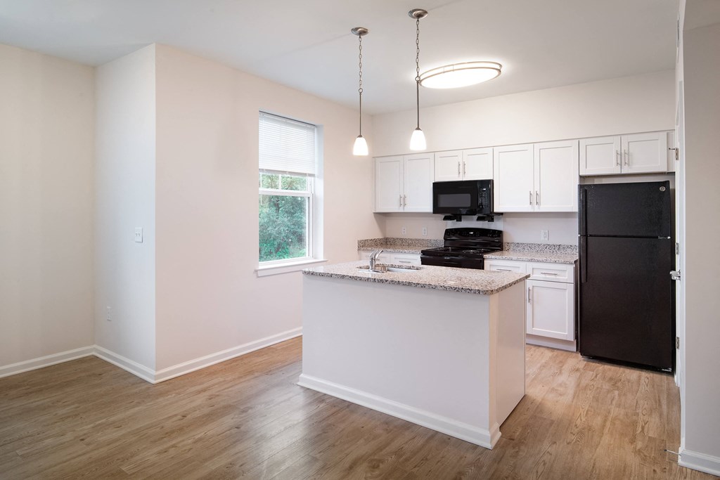 a kitchen with an island and a black refrigerator