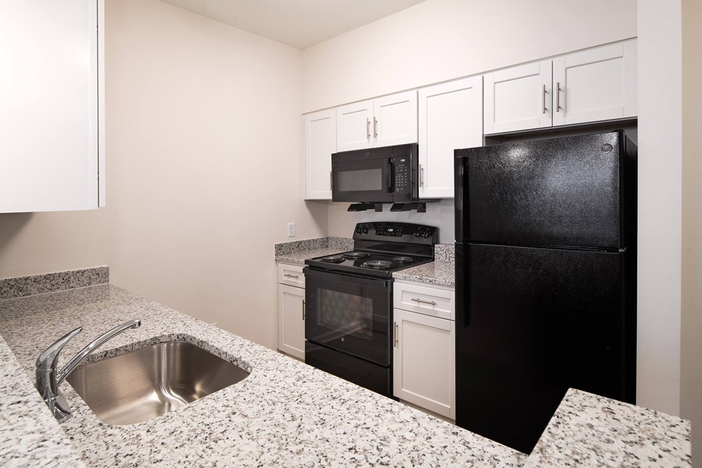 a kitchen with granite counter tops and black appliances