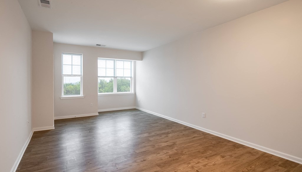 an empty living room with white walls and wood floors