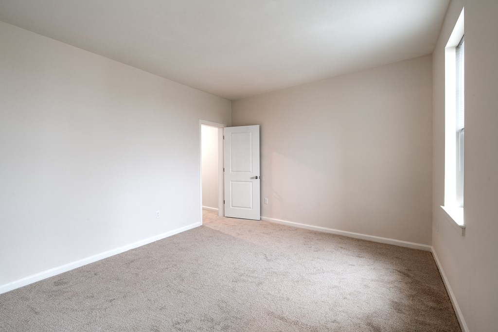 an empty living room with white walls and a white door