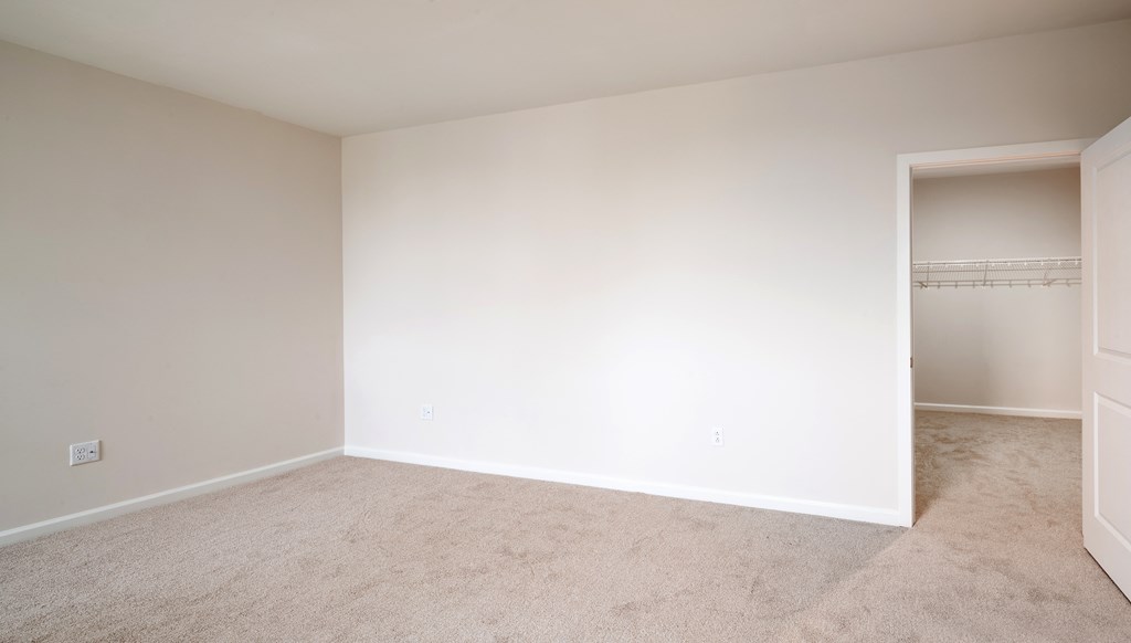 an empty room with white walls and a closet