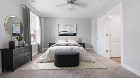 A bedroom with a large bed, a dresser, and a mirror.