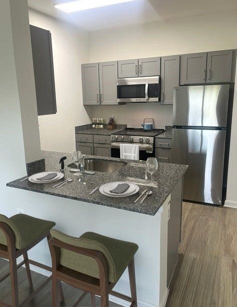 A kitchen with a stove, microwave, and refrigerator.